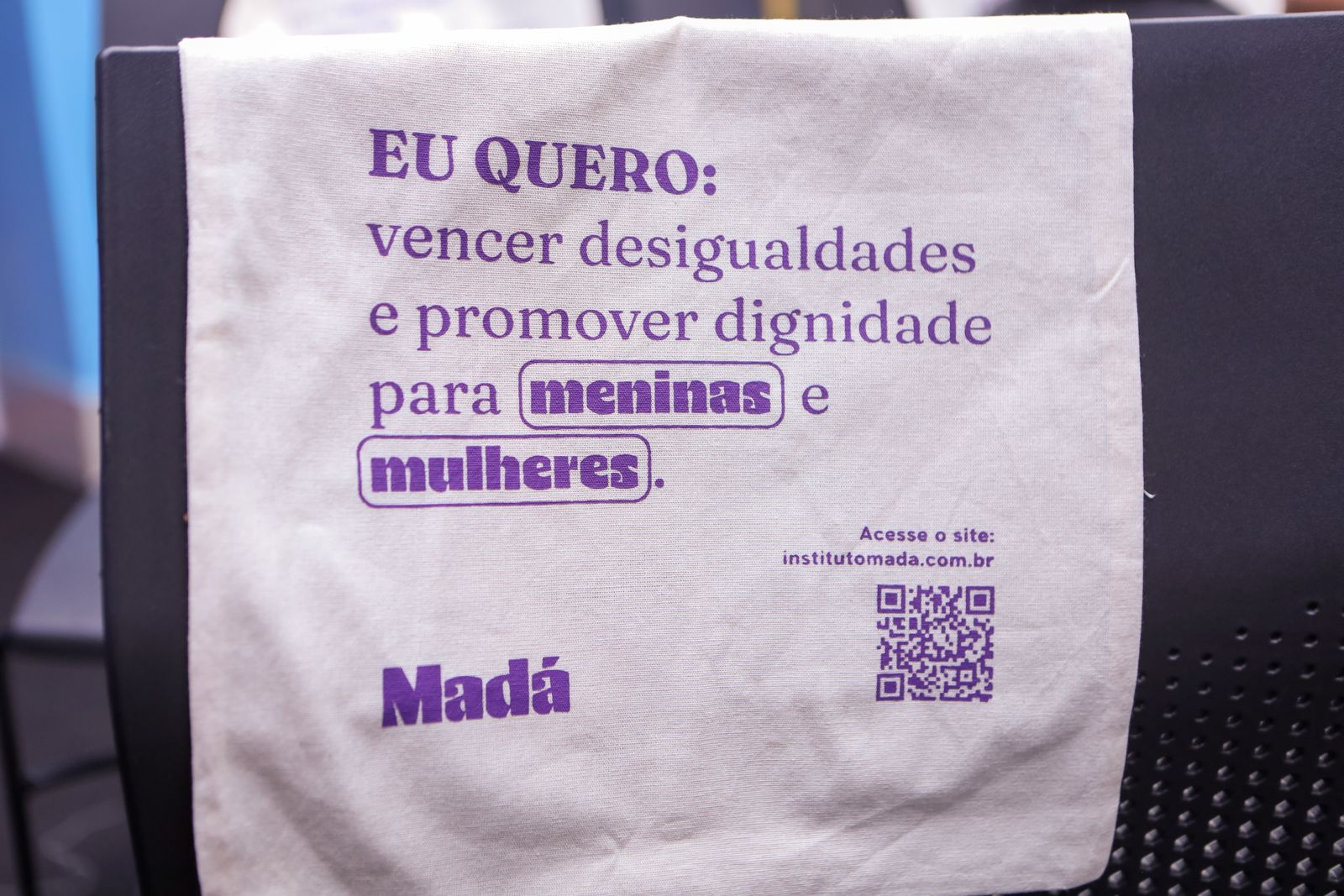 Event tote bags carry the phrase “Eu quero: vencer desigualdades e promover dignidade para meninas e mulheres” (I want to overcome inequalities and promote dignity for girls and women).